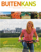 Cover van Buitenkans magazine nummer 3: fietsende vrouw op het platteland met in de achtergrond een stadsrand