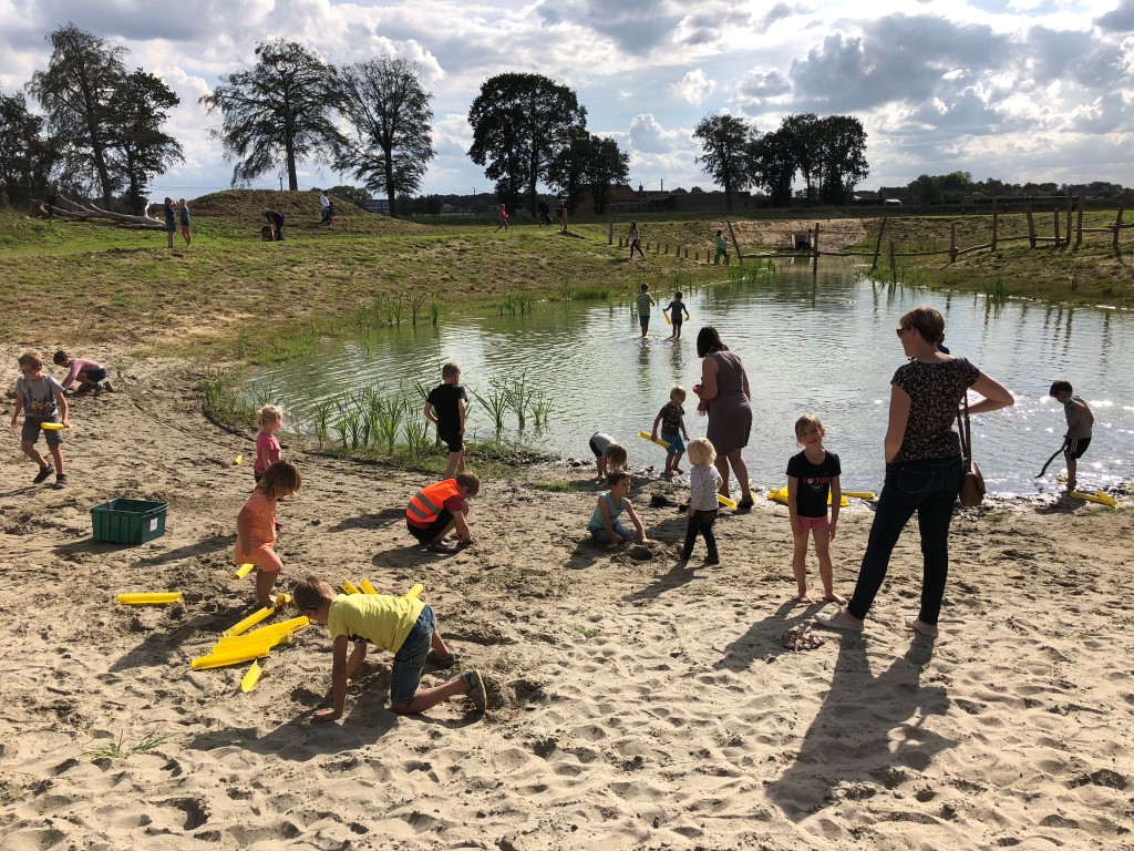 spelende kinderen aan de ondiepe poel en het strandje