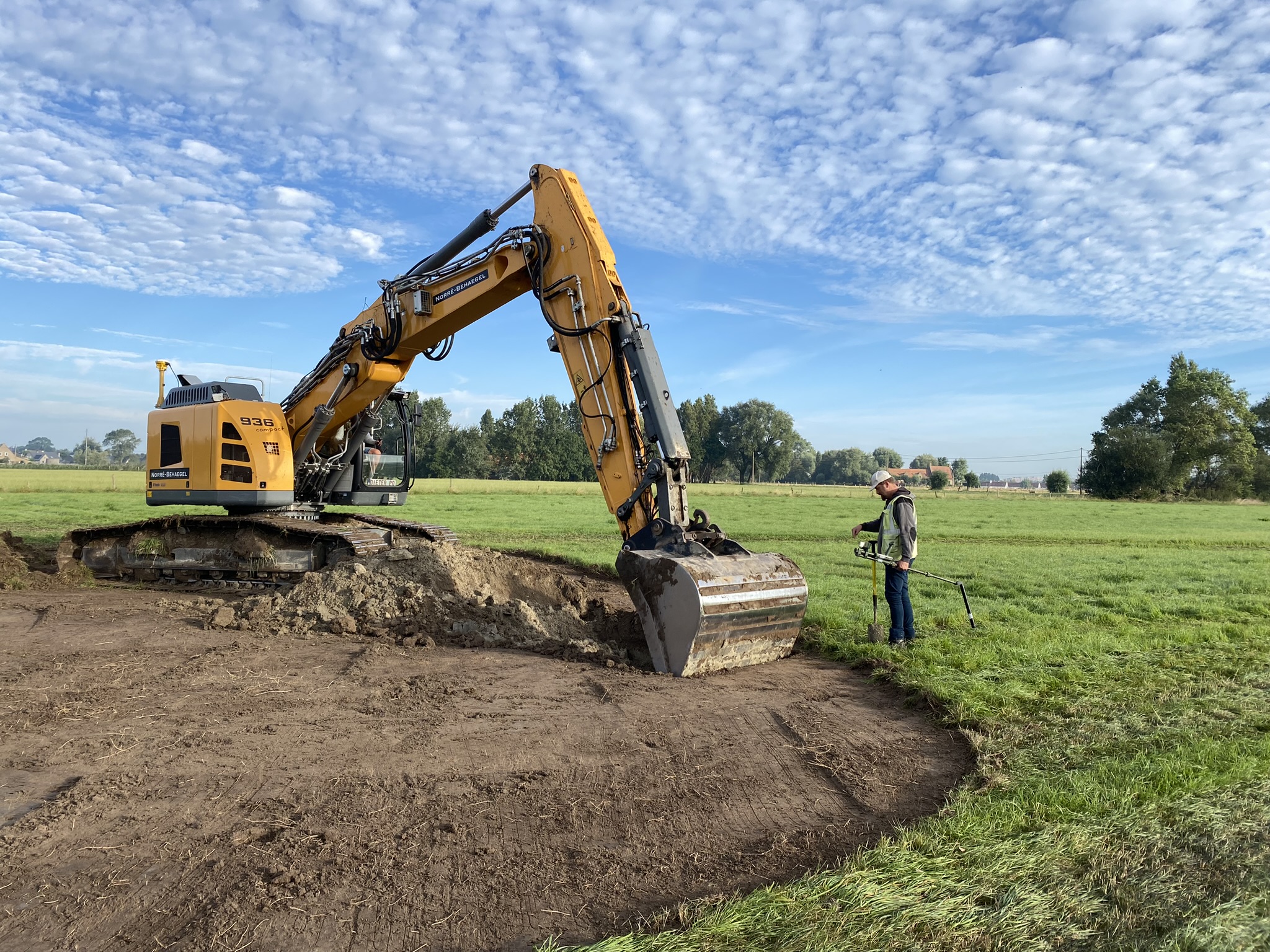 grondwerken met kraan en arbeider in actie in Schuddebeurze
