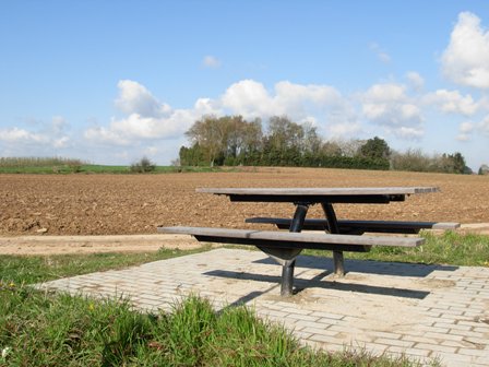 picknickplaats met bank, akker op de achtergrond